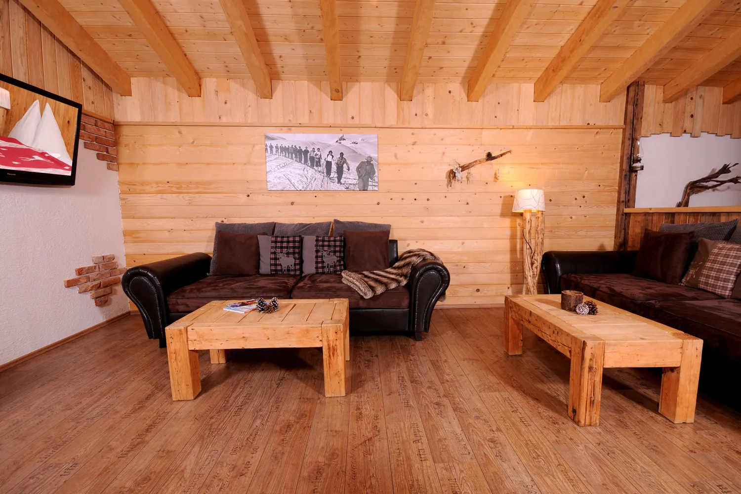 Wohnstube mit Ledersofas und Holzwänden im Almchalet Dorfblick