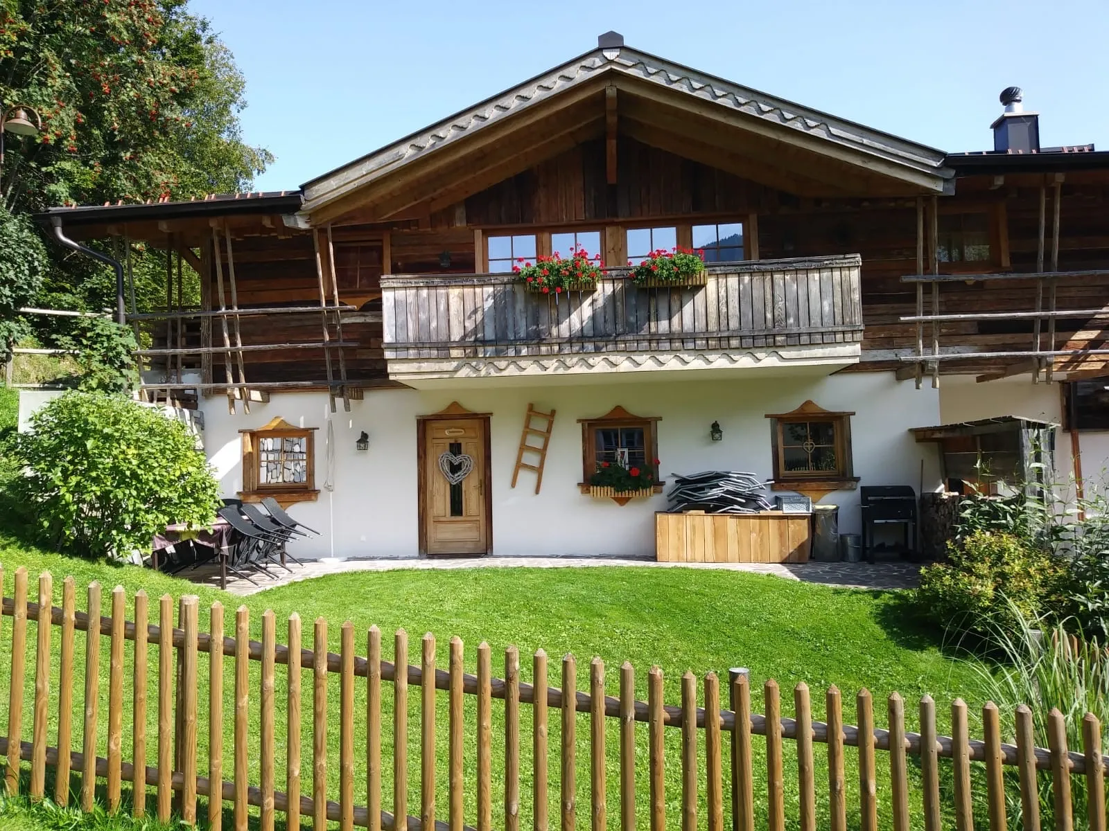 Almchalet Schneeberg mit Holzbalkon und Garten an einem Sommertag