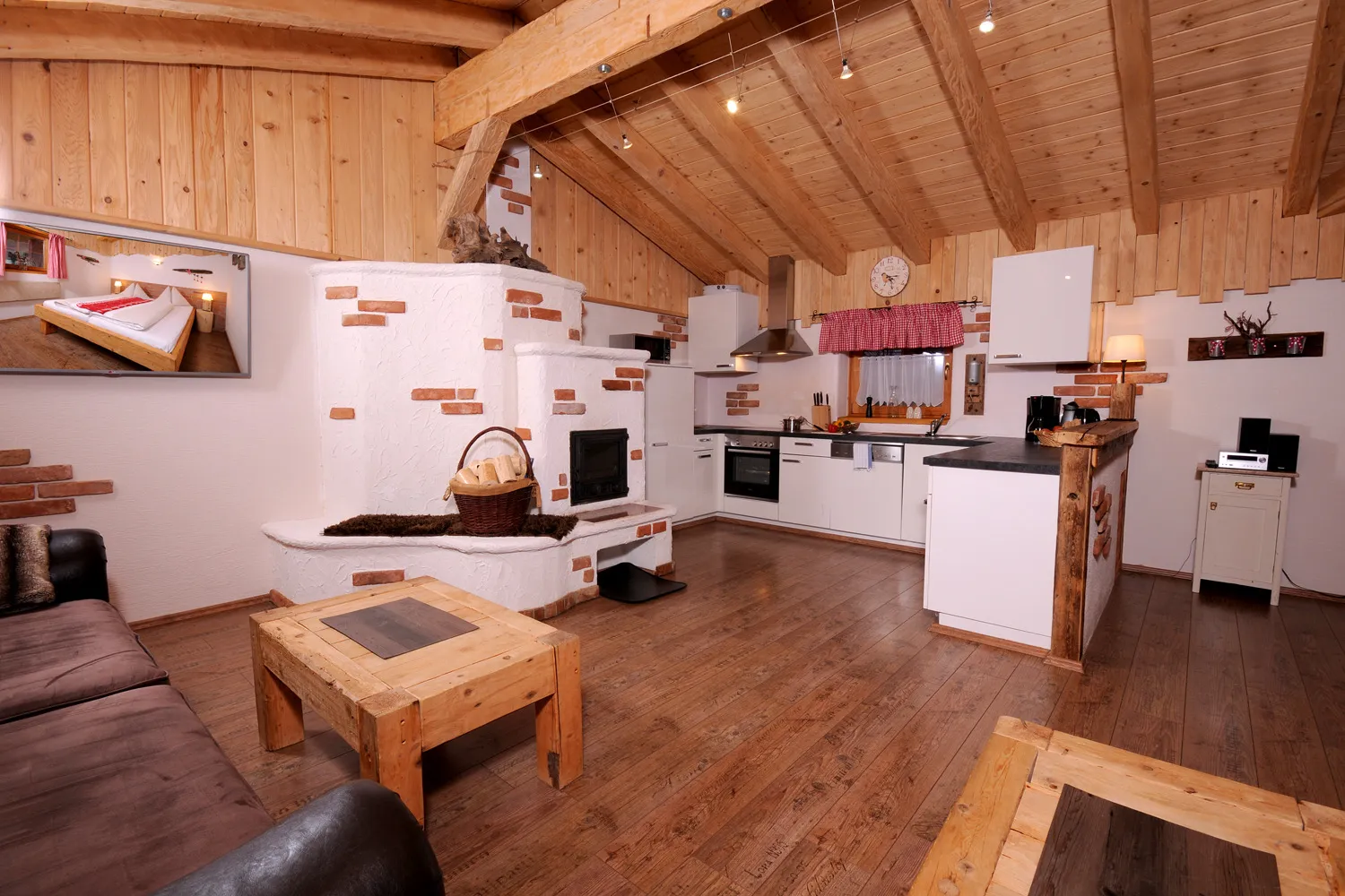 Offene Wohnküche mit Kachelofen und Sitzecke im Almchalet Schneeberg